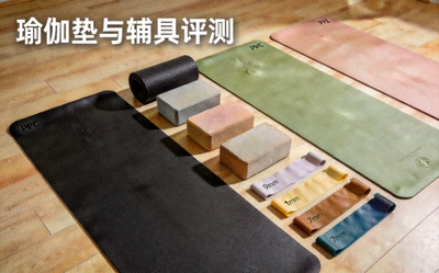 瑜伽垫与辅具评测 - 多种材质和厚度的瑜伽垫铺展在木地板上，旁边摆放着瑜伽砖和伸展带
